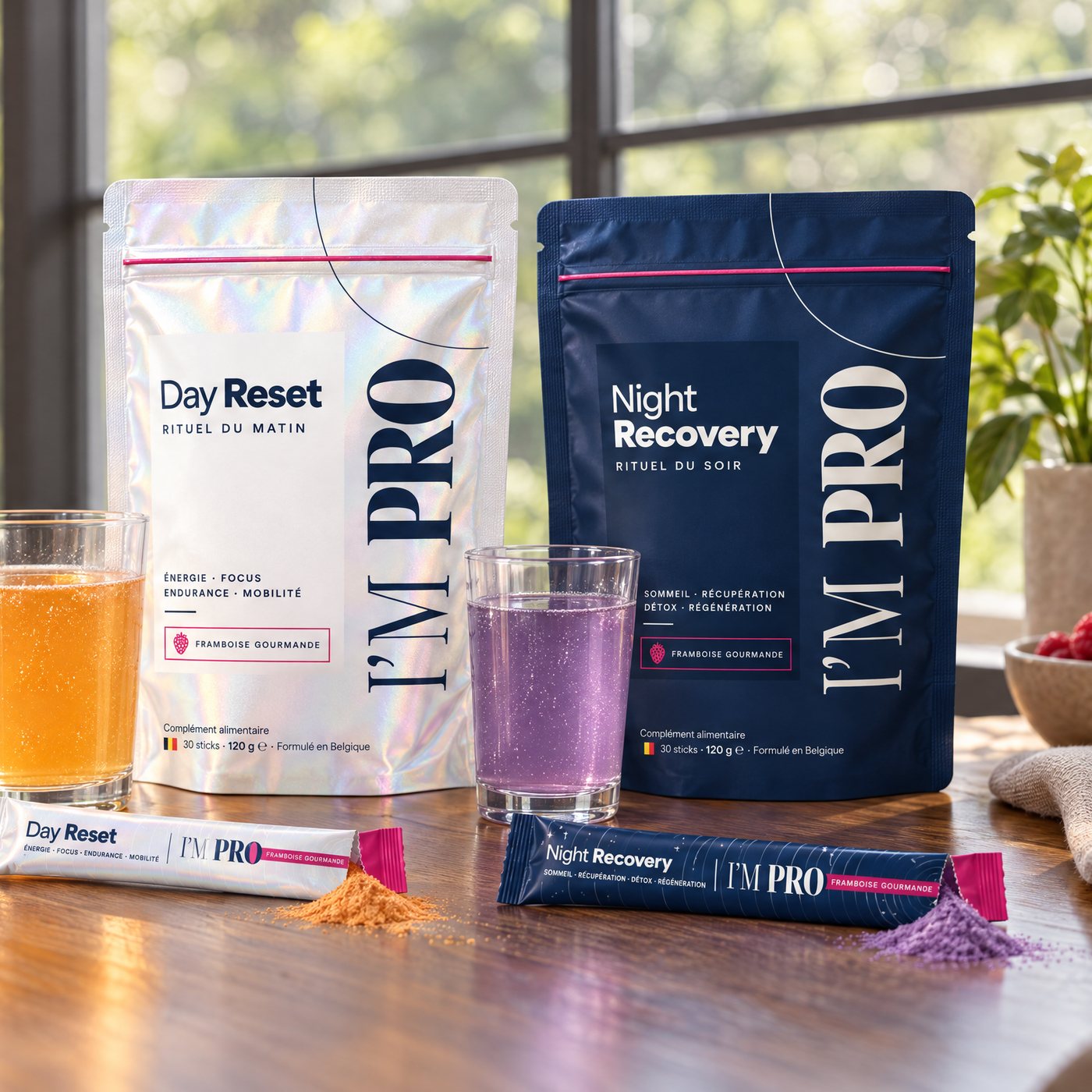 Les sachets Day Reset et Night Recovery posés sur une table, avec un verre de chaque boisson