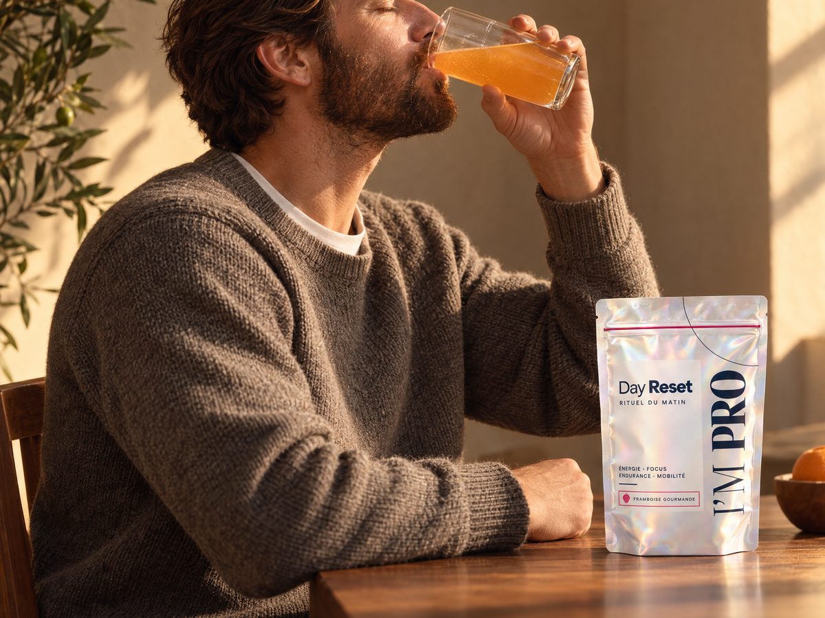 Au soleil du matin, un homme boit son verre de Day Reset, le sachet posé sur la table.